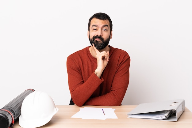 Hombre arquitecto en una mesa con planes y casco