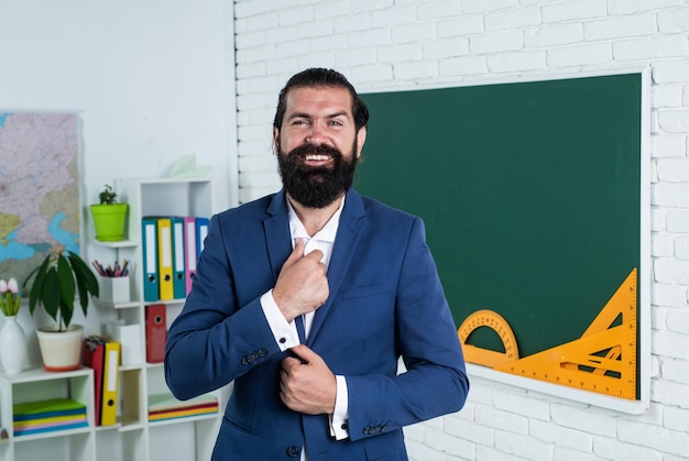 Foto hombre arreglando corbata y usando traje formal en la educación de lecciones de la escuela de negocios
