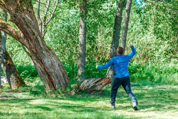 Foto un hombre arroja un cuchillo a un árbol.