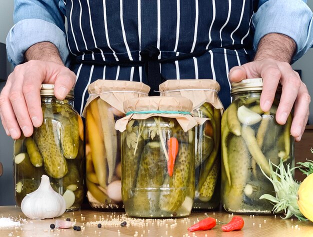 Hombre artesanal está haciendo pepinillos frascos stock para la temporada de invierno pepinillos caseros orgánicos