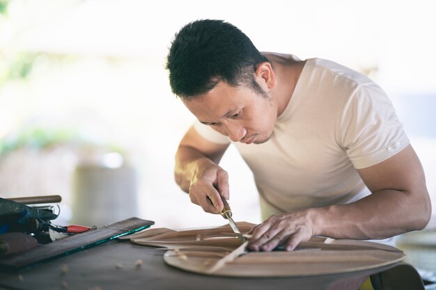 Hombre de artesanía haciendo guitarra en la mesa de madera, concepto de trabajo capenter