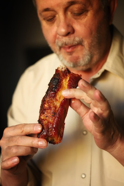 Un hombre en un asador come carne.