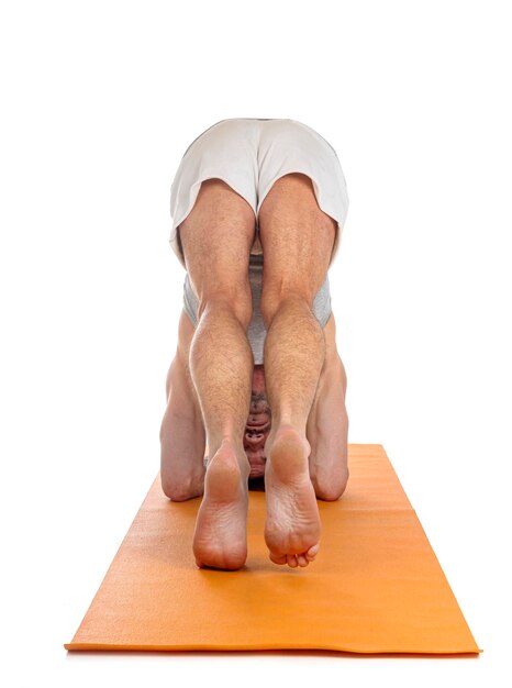 Foto hombre y asana de hatha yoga frente a un fondo blanco