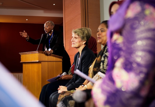 Un hombre de ascendencia africana hablando en un podio en una sala llena de delegados internacionales
