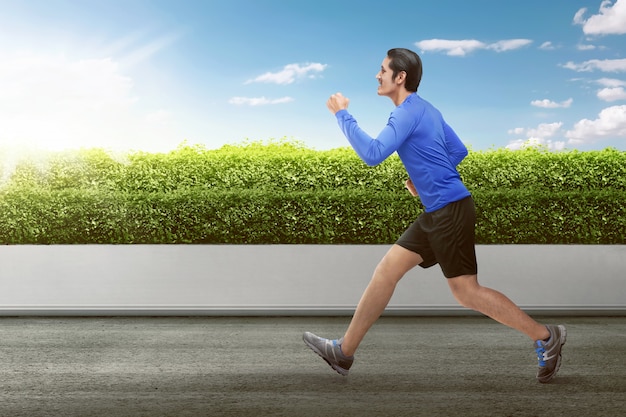 Foto hombre asiático atractivo que corre en la mañana