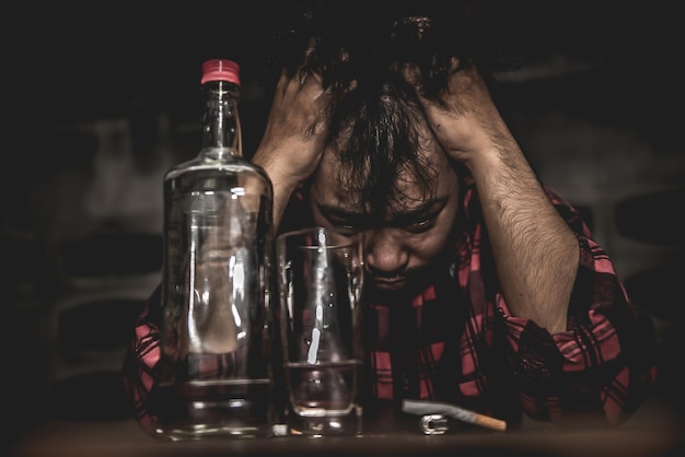 Hombre asiático bebe vodka solo en casa por la noche Gente tailandesa Concepto borracho de hombre estresado