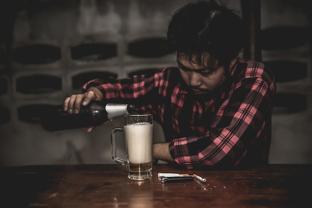 Hombre asiático bebe vodka solo en casa por la noche Gente tailandesa Concepto borracho de hombre estresado