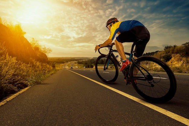 Hombre asiático en bicicleta en una carretera abierta