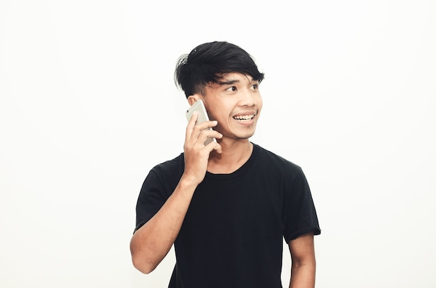 Un hombre asiático con una camisa negra casual está al teléfono