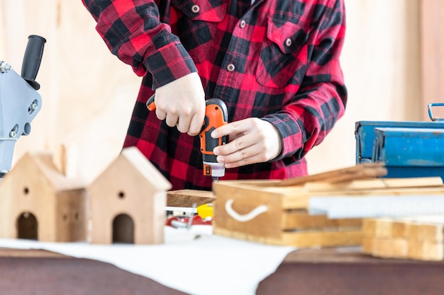 Hombre asiático carpintero trabajando en carpintería en taller de carpintería Carpintero trabajando en artesanía de madera en taller material de construcción muebles de madera Hombre asiático trabaja en un taller de carpintería