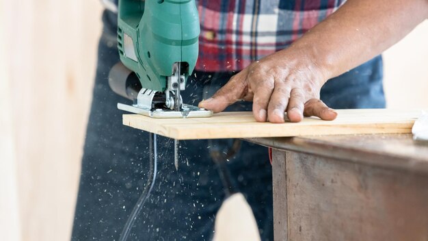 Hombre asiático carpintero trabajando en carpintería en taller de carpintería Carpintero trabajando en artesanía de madera en taller material de construcción muebles de madera Hombre asiático trabaja en un taller de carpintería