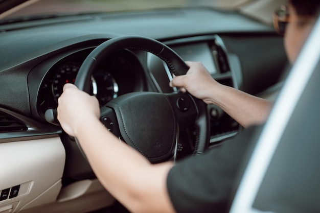 Hombre asiático conduciendo un automóvil en la carretera Concepto de automóvil de conducción