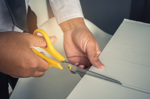 Hombre asiático cortando papel con tijeras para manualidades