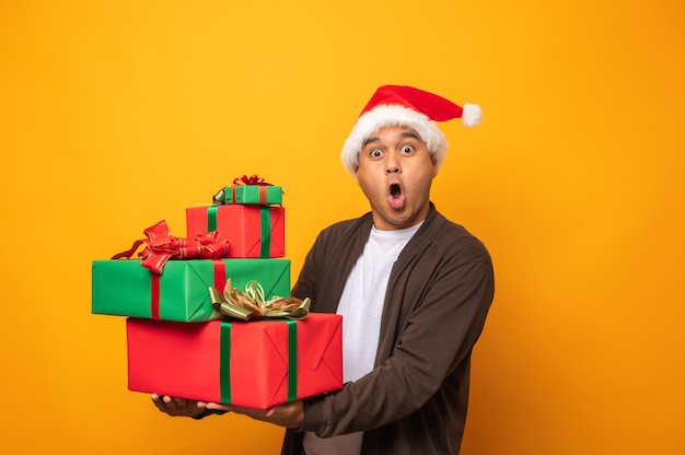 Hombre asiático emocionado feliz en el día de Navidad que sostiene la caja de regalo actual.