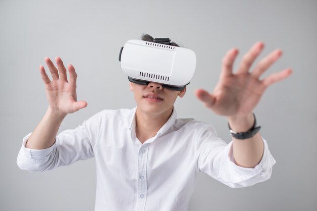 Hombre asiático emocionado en unas gafas de realidad virtual y gesticulando con las manos