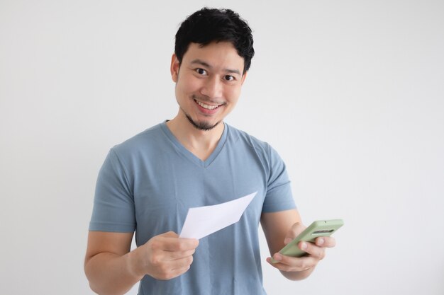 Hombre asiático es feliz por el teléfono inteligente y la factura en gris