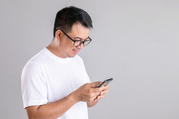 Hombre asiático escribiendo o charlando en el teléfono inteligente