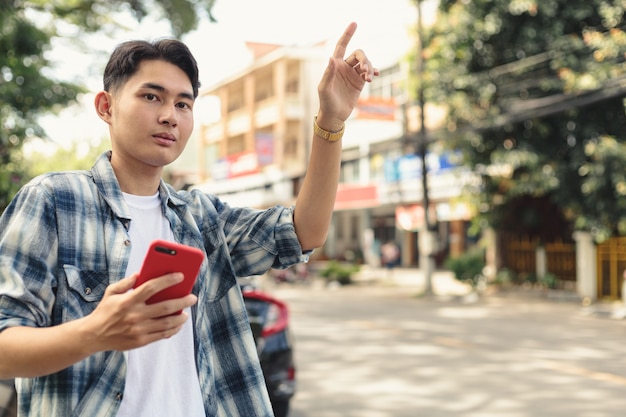 Foto hombre asiático esperando taxi uber