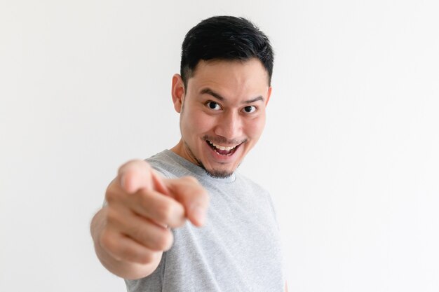 El hombre asiático está apuntando a la cámara con una expresión facial emocionada.