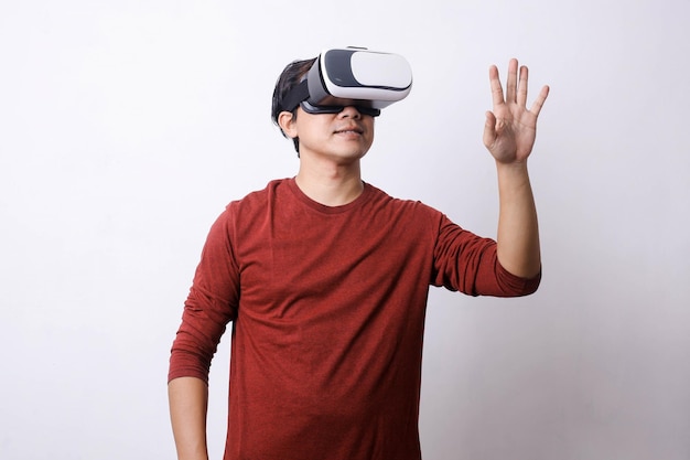 Hombre asiático en estilo casual usando gafas de Realidad Virtual y ipad está haciendo mo movimiento studio shot