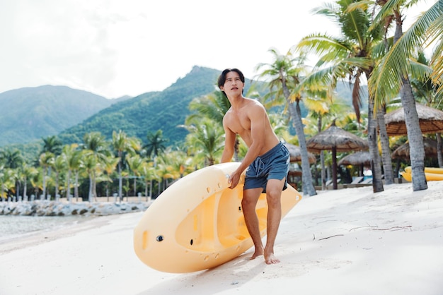 Hombre asiático feliz en kayak en una playa tropical aventura de verano