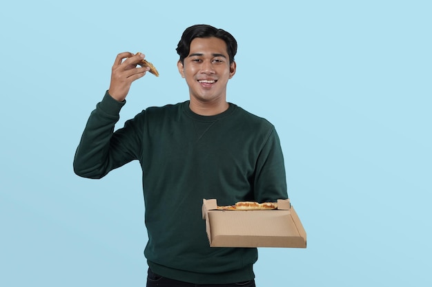 Hombre asiático feliz tipo sosteniendo una caja abierta con una sabrosa pizza italiana disfrutando del servicio de entrega de alimentos