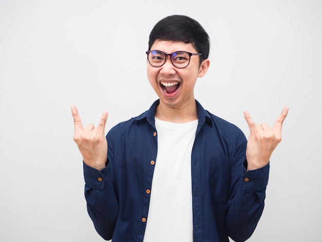 Hombre asiático con gafas muestran rockero de mano sintiéndose feliz gritando