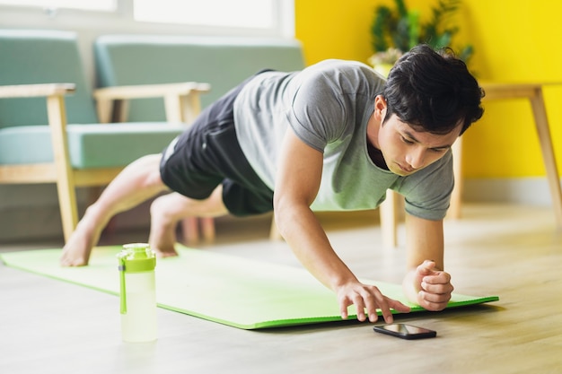 Hombre asiático haciendo ejercicio en casa