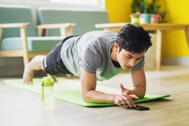 Hombre asiático haciendo ejercicio en casa