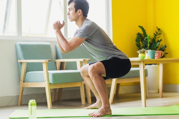 Hombre asiático haciendo ejercicio en casa