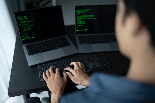 Hombre asiático ingeniero de software Trabajando en la computadora en el escritorio de la oficina para escribir código de programa Ingeniero de software de TI encontrando errores soporte técnico devops creando digital
