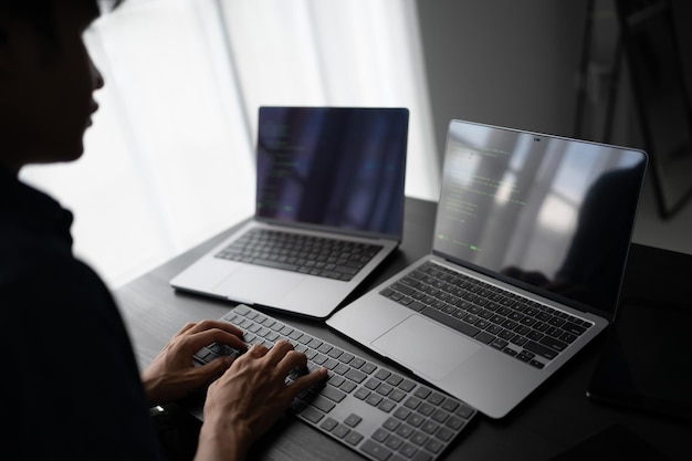 Hombre asiático ingeniero de software Trabajando en la computadora en el escritorio de la oficina para escribir código de programa Ingeniero de software de TI encontrando errores soporte técnico devops creando digital