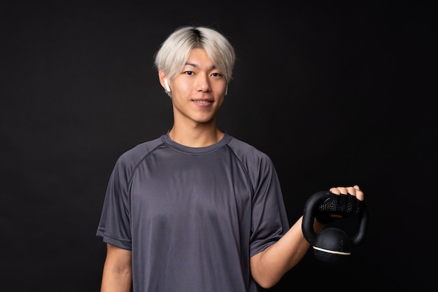 Hombre asiático joven del deporte sobre negro aislado