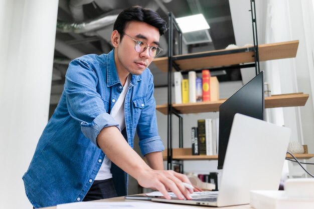 Hombre asiático joven que trabaja en la oficina