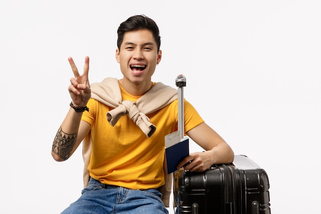 Hombre asiático lindo en camiseta amarilla listo para un viaje con un pasaporte