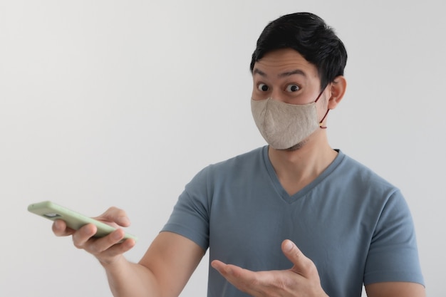 Hombre asiático con máscara está contento con la promoción en la aplicación para teléfonos inteligentes.
