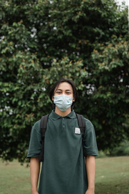 Hombre asiático con máscara en un parque para prevenir la propagación del covid 19