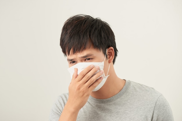 Hombre asiático con una mascarilla con tos