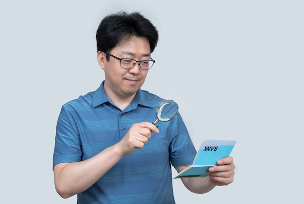 Un hombre asiático de mediana edad con una libreta de banco en la mano