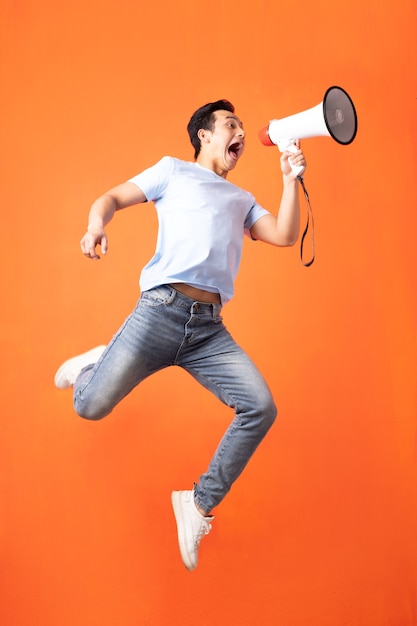 Foto hombre asiático con megáfono y gritando