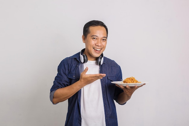 Hombre asiático muestra fideos instantáneos en su mano con una gran sonrisa