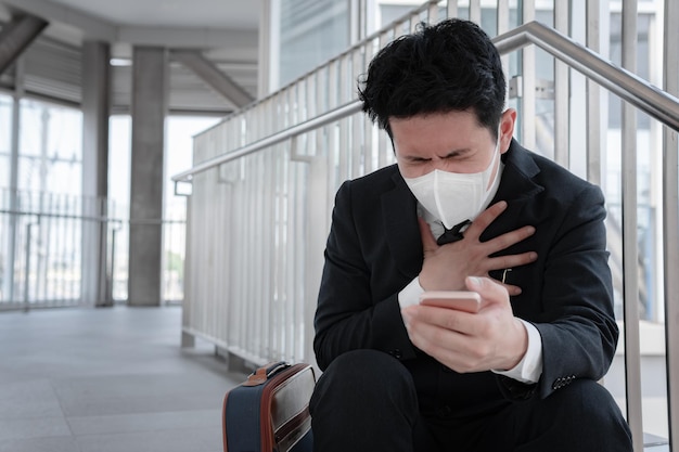 Hombre asiático de negocios en la ciudad de tailandiaHombre guapo con máscara médica de protección covid19 o coronavirus de una persona infectada