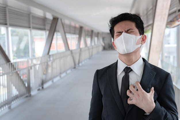 Hombre asiático de negocios en la ciudad de tailandiaHombre guapo con máscara médica de protección covid19 o coronavirus de persona infectadacorona protegida Ayuda a proteger Para el mundo y las personas detienen la advertencia de virus