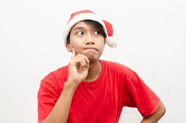 hombre asiático de pensamiento feliz en ropa de tema de navidad santa con gesto de pensar y preguntarse.