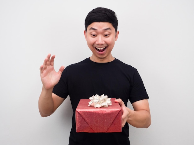 Hombre asiático que se siente emocionado y feliz con una caja de regalo en la mano