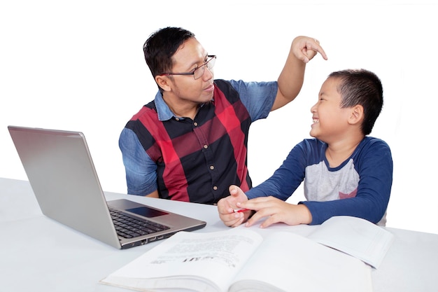 Hombre asiático regañando a su hijo mientras estudia