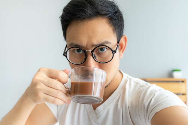 El hombre asiático selfy se bebe el café.