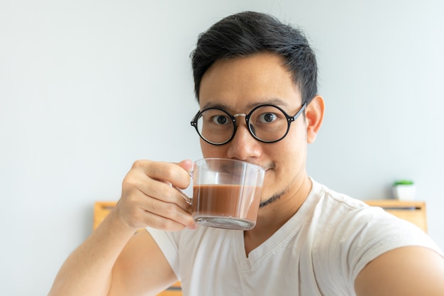 El hombre asiático selfy se bebe el café.
