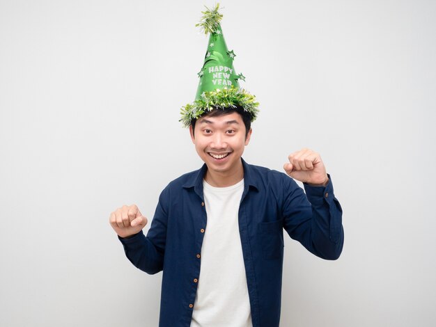 Hombre asiático con sombrero verde gesto divertido baile con concepto de celebración de año nuevo