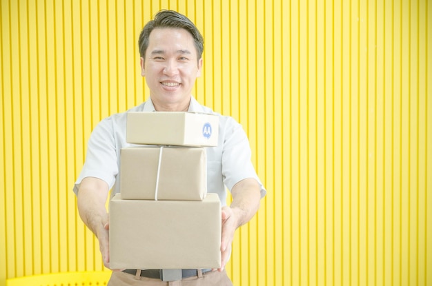 El hombre asiático sonrió y le entregó la caja al comprador. Los propietarios de negocios están entregando productos a los clientes.